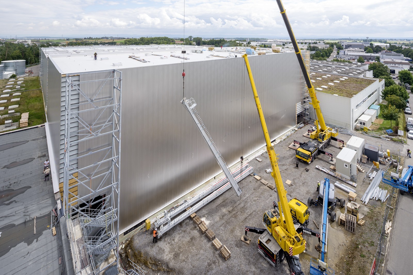 Außenfassade eines Logistikzentrums im Bau mit Kränen