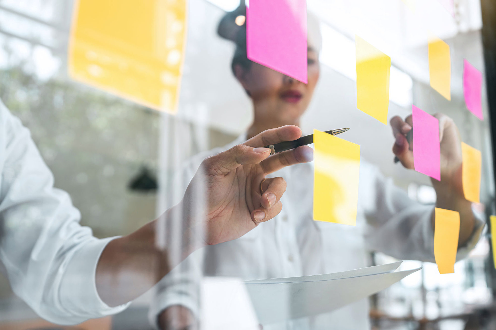 Glaswand mit Post-Its, auf der Experten eine Bewertung durchführen